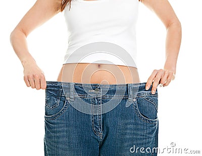 Slim woman pulling oversized jeans Stock Photo