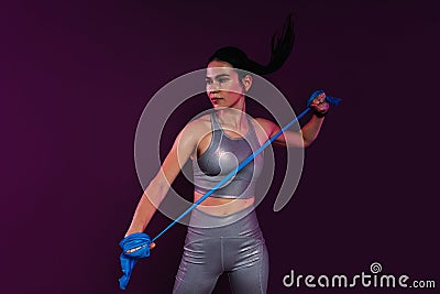 Slim woman wearing silver fitness attire exercising Stock Photo