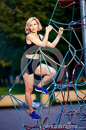 Slender woman in sportswear makes sport outdoors. Stock Photo