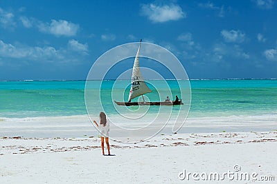 Slim yang lady on whitesand beach looking to sail Editorial Stock Photo