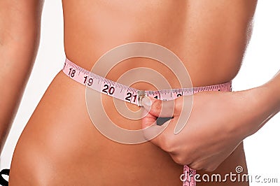 Slim young woman measuring waist Stock Photo