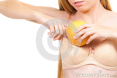 Woman small boobs puts big fruit in her bra Stock Photo