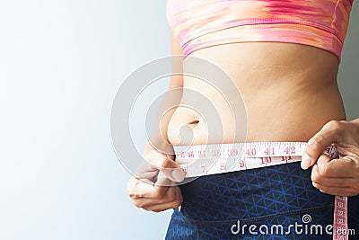Slimming woman with belly fat, Sporty woman measuring belly fat. Stock Photo