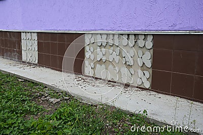 Slipped, broken, fallen off ceramic tiles, missing wall tiles on a house foundation wall caused by the basement, foundation Stock Photo