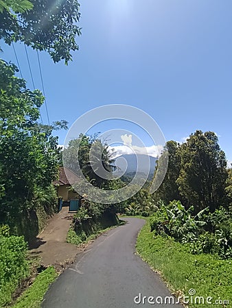 sloping road in the countryside of Munduktemu with views of Mount Batukaru Stock Photo