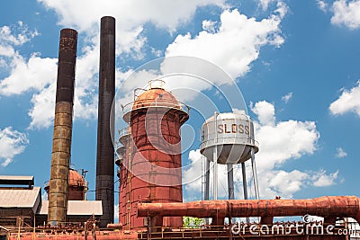 Sloss Furnaces National Historic Landmark, Birmingham Alabama USA, water tower, furnaces and smoke stacks, blue sky with clouds Stock Photo