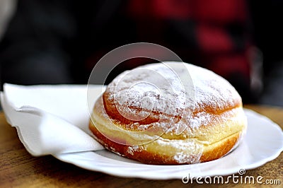 Slovenian traditional local Krapfen on a white dish on a wooden table in a bakery restaurant in Lubiana Stock Photo