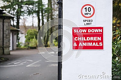 Slow down road safety caution children and animals at zoo entrance Stock Photo