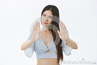 Slow down and stop. Portrait of displeased serious-looking strict female with long dark hair frowning and pursing lips Stock Photo