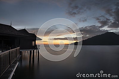 Slow exposure shot of the golden hour of the unique architectural wooden houses or villas on stilts by the sea Editorial Stock Photo