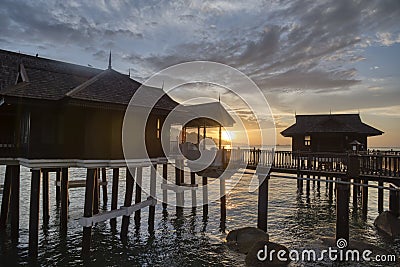 Slow exposure shot of the golden hour of the unique architectural wooden houses or villas on stilts by the sea Editorial Stock Photo