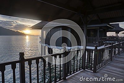 Slow exposure shot of the golden hour of the unique architectural wooden houses or villas on stilts by the sea Editorial Stock Photo