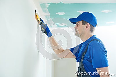 Refurbishment. Worker spackling a wall with putty Stock Photo