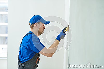 Refurbishment. Worker spackling a wall with putty Stock Photo