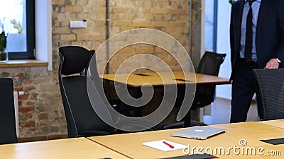 Slow motion video. Caucasian man is coming into the office, siting down, opening computer, and starting to work on his Stock Photo