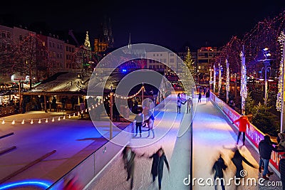 Night scenery at ice rink with people enjoy ice skating at Heumarkt, famous Christmas market square in KÃ¶ln. Editorial Stock Photo