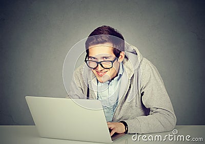 Sly devious man using a laptop plotting server sabotage Stock Photo