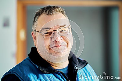 Sly smile of round faced European man over 40 wearing glasses. Stock Photo