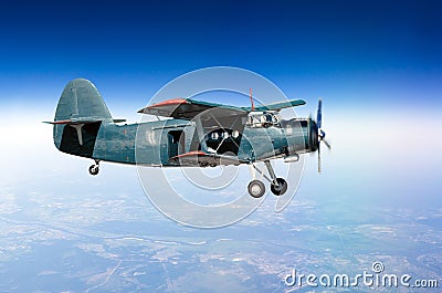 Small aircraft turboprop biplane at high altitude in the sky above the ground with an open door. Stock Photo