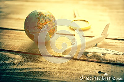Small airplane and Globe and Magnify Glasses on wooden table tex Stock Photo