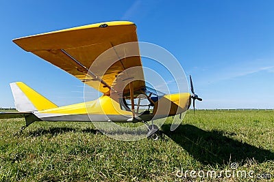 small airplane waiting on field, Yellow plane on the grass. Stock Photo