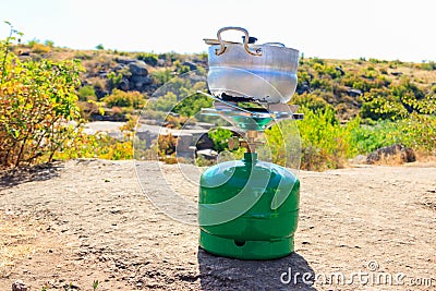 Small aluminum pan on propane gas cylinder with burner for cooking outdoor. Equipment for cooking in the open air Stock Photo