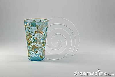 A small aquamarine Antique Glass, Vase or water Beaker with a depiction of a Honey Bee on flowers in Enamel with Gold Gilt. Stock Photo