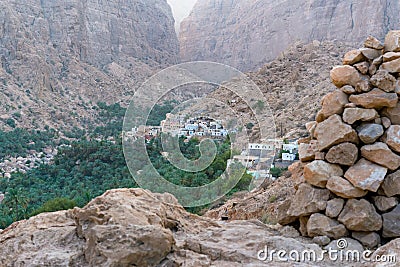 Small arabian mountain village of Mibam in the gorge of Wadi Tiwi, Oman. Steep sandstone cliffs, green palm trees in the Editorial Stock Photo