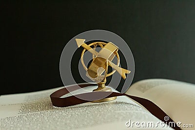 A small astrolabe globe on an open book as a symbol of study and wisdom Stock Photo