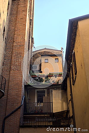 Small balcony with potted plants fitted in a shady alley in an italian town at sunset Stock Photo