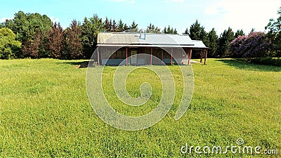 A small barn in a green meadow Stock Photo