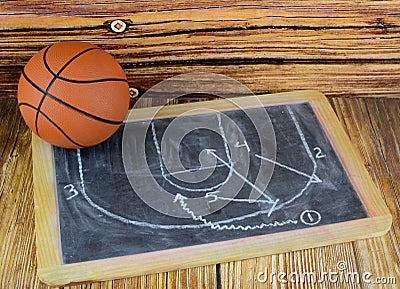 A small basketball and a chalkboard showing a classic pick and roll play. Stock Photo