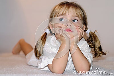 Small beautiful girl in white tanktop on beds Stock Photo