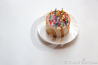 Small birthday cake with bright candles Stock Photo