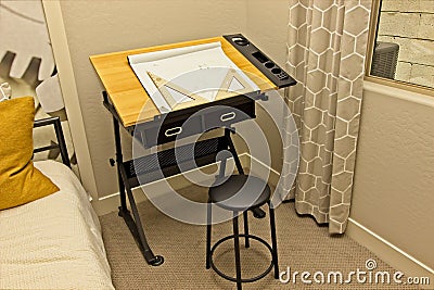 Small Black Drafting Table In Bedroom Corner Stock Photo