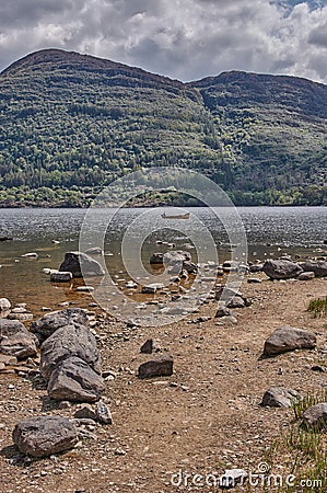 Small boat driving on Lough Lean in Ireland. Lough Leane at the Ring of Kerry. Mountain lake in Ireland Stock Photo