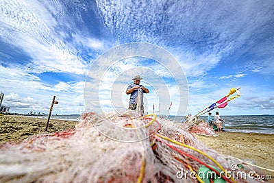 A small boat local fishery group is removing crabs, fish and sea creatures caught from their nets at Jomtien Beach Editorial Stock Photo