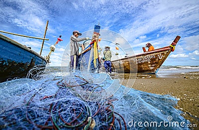 A small boat local fishery group is removing crabs, fish and sea creatures caught from their nets at Jomtien Beach Editorial Stock Photo