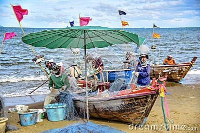 A small boat local fishery group is removing crabs, fish and sea creatures caught from their nets at Jomtien Beach Editorial Stock Photo