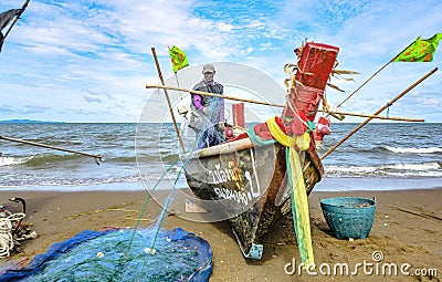 A small boat local fishery group is removing crabs, fish and sea creatures caught from their nets at Jomtien Beach Editorial Stock Photo