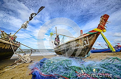 A small boat local fishery group is removing crabs, fish and sea creatures caught from their nets at Jomtien Beach Editorial Stock Photo