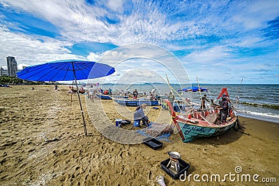 A small boat local fishery group is removing crabs, fish and sea creatures caught from their nets at Jomtien Beach Editorial Stock Photo