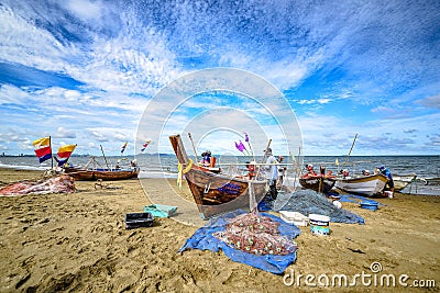 A small boat local fishery group is removing crabs, fish and sea creatures caught from their nets at Jomtien Beach Editorial Stock Photo