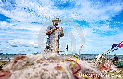 A small boat local fishery group is removing crabs, fish and sea creatures caught from their nets at Jomtien Beach Editorial Stock Photo