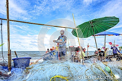 A small boat local fishery group is removing crabs, fish and sea creatures caught from their nets at Jomtien Beach Editorial Stock Photo