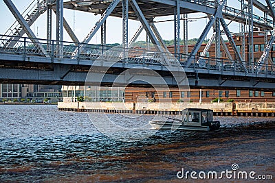 Small boat sailing under the Duluth Aerial Lift Bridge during the daytime Editorial Stock Photo