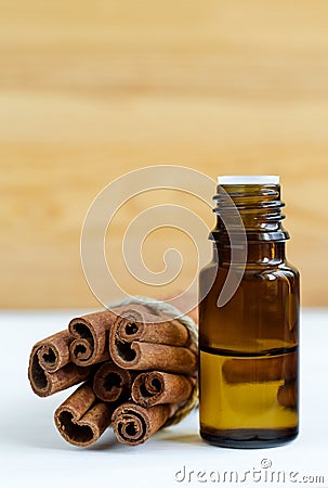 Small bottle with essential cinnamon oil. Cinnamon sticks close up. Aromatherapy, spa and herbal medecine concept. Stock Photo