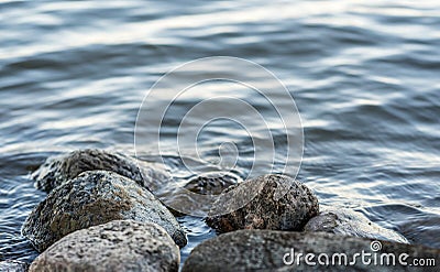 Small boulders submerged in water of a lake on a lakeshore Stock Photo