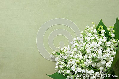 Small Bouquet of Lily of the Valley Flowers with Green Leaves on Beige Vintage Background. Wedding Birthday Mother`s Women`s Day Stock Photo