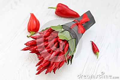 Small bouquet made of hot chilli pepper and the bay leaves on a white wooden table Stock Photo